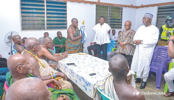 Dr Mahamudu Bawumia, the Vice-President (standing right) with Dr Yao Archibald Letsa, the Volta Regional Minister, speaking during his call on the Chief and elders of Kpedze