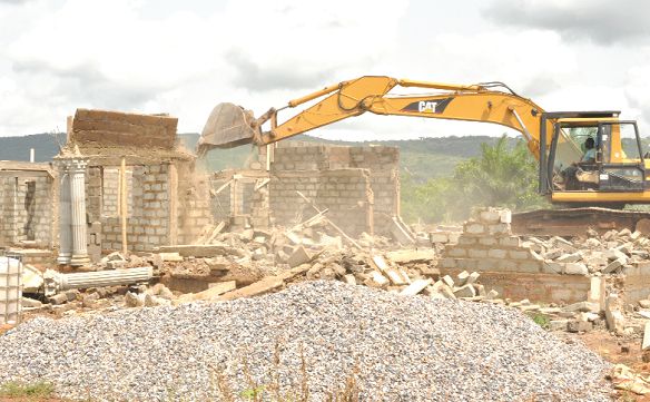  An excavator pulling down one of the structures at the site. Picture: Nii Martey M. Botchway