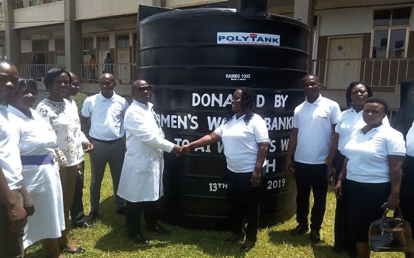 The CEO (right) presenting the tank to Dr Asubonteng. Looking on are officials of the bank and the hospital