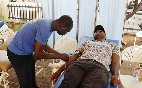 Mr Abdul Ganiwu preparing a donor to donate blood