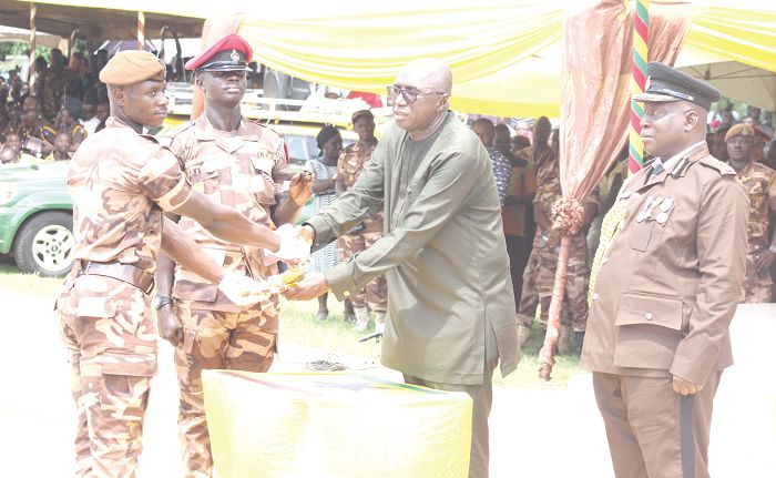 Mr Ambrose Dery (2nd right), presenting the Best All Round Award to Recruit Officer (RO)  Paul Dzidefo Sakyi (left). Looking on is Mr Samuel Adjei-Attah (right), Commandant, Prison Officers Training School (POTS)