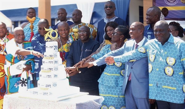 Dr Mahamudu Bawumia (4th left) being assisted by Togbe Afede XIV (3rd left) and other officials of the school to cut the anniversary cake. 