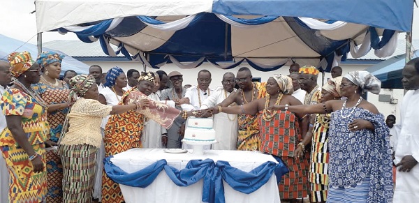   Apostle Attipoe (middle) being assisted by traditional rulers and some members of the church to cut the 80th anniversary cake