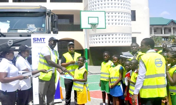 Mr Jasper Agbakpe (3rd left) leads the SMT Ghana team to hand over certificate of participation to the children 