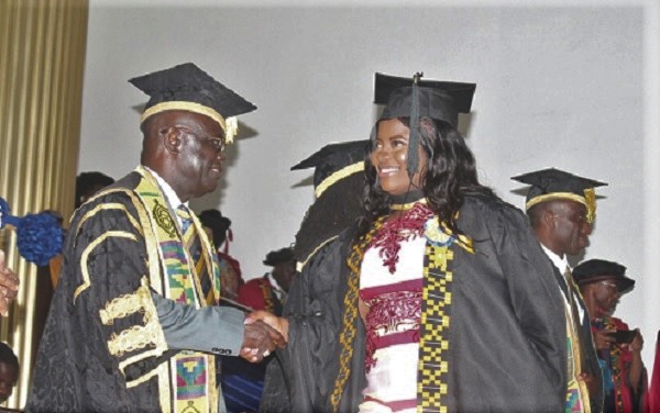 Ms Patience Issaka (right), a graduate in Bachelor of Fine Arts, in a handshake with Prof. Ebenezer Oduro Owusu (left), Vice-Chancellor, University of Ghana (UG), during the congregation.