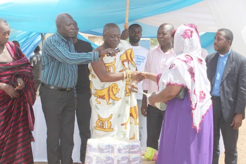  Nana Opoku Ofosu Gyeabour (2nd left), Koasehene and Mawerehene of Techiman Traditional area, presenting a sanitary item to a participant in the event   
