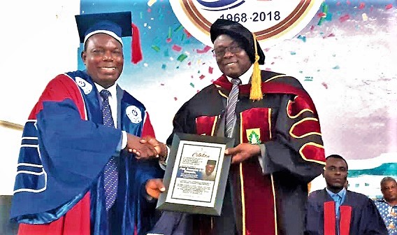 Professor Domwini Dabire Kuupole (Right), former Vice-Chancellor of the University of Cape Coast, receiving a citation from Prof. Ben Q. Hoenyenuga, Vice-Chancellor, HTU