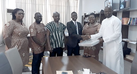  Mr Adam (right) presenting the prize to Evans Tettey Odjer, while Mr Addo and other members of ICAG look on