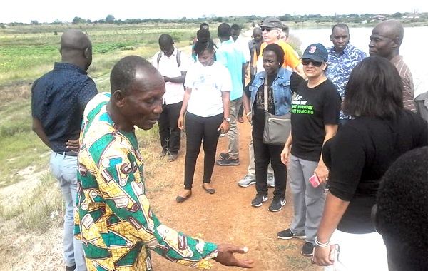 Mr Samuel Ayeh (left) a farmer, briefing the team from ACEP and OXFAM on some of the challenges facing the farmers with the current state of the dam