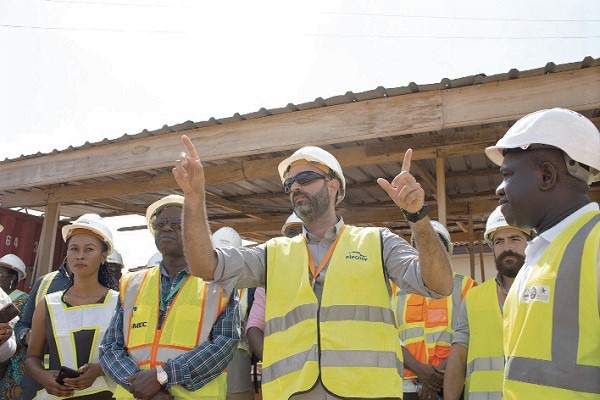 Mr Manuel Jesus Galan Garcia (hands raised), the Site Manager at the Bulk Power Supply Point at Pokuase in the Greater Accra Region, briefing the MiDA team on the progress of work. 
