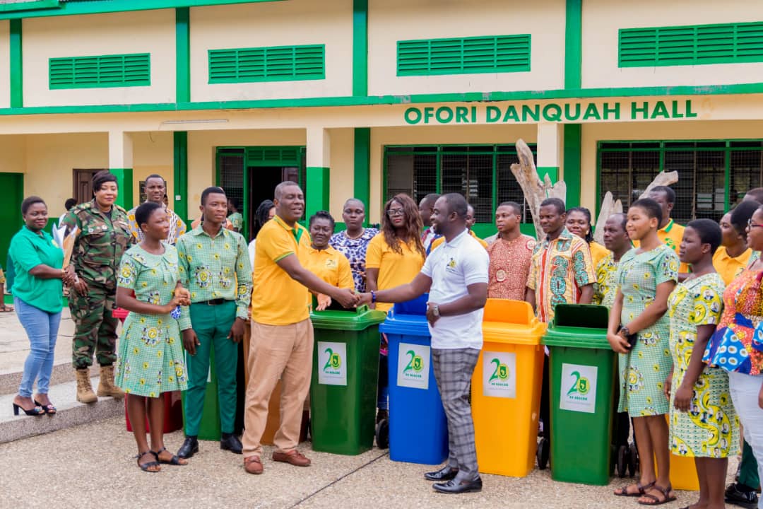 President of the 1999 Year Group, Elvis Nyarko Anipah (right) presenting the dustbins to Headmaster of the School, Mr Jacob Afful (3rd from left) while students, staff and some of the old students look on