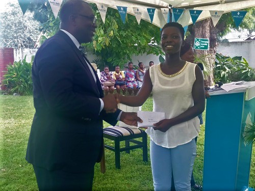 Mr Roland Akosah (left), Chairman of the Board of Trustee, NPTC presenting a Cheque to one of the beneficiaries at the award ceremony