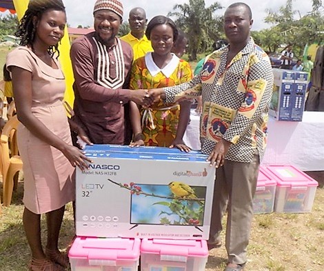  Mr Isaac Kwadwo Okyere (right) presenting flat screen digital TV sets and other educational materials to a teacher of one of the beneficiary schools 
