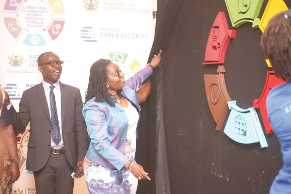 Mrs Ursula Owusu Ekuful (right), the Minister of Communications, unveiling a logo after the launch, as Dr Albert Antwi-Boasiako (left), the National Cyber Security Advisor, looks on. 