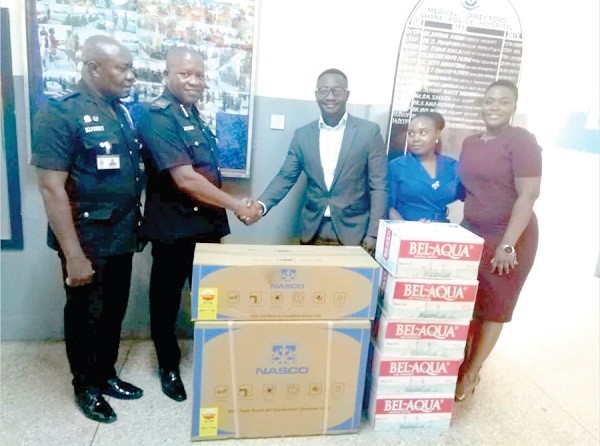  Mr Owusu Yaw Osei-Bobie (3rd right), Operations Manager of GUA LIFE, in a handshake with ACP Mr Victor Adusah-Poku, the Police Hospital Administrator