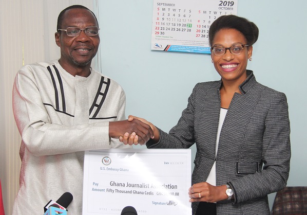 Mr Affail Monney (left) receiving the cheque for GH₵50,000 from Naomi Mattos (right) 