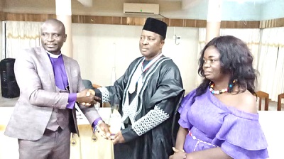 Apostle Dr Stephen Asante (left) presenting Mr Okyeahene with his award. With them is Mrs Mavis Essel Okyeahene
