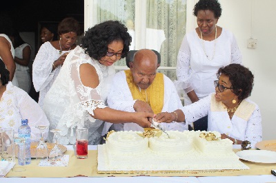 Dr Emmanuel Evans-Anfom (middle), former Vice Chancellor of the Kwame Nkrumah University of Science and Technology, being assisted by wife Eliza (seated right) and some family members to cut the birthday cake. Picture: GABRIEL AHIABOR