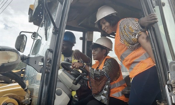 Ms Adwoa Safo (right) and Ms Janet Tulasi Mensah (middle) onboard the heavy machine during the sod cutting ceremony