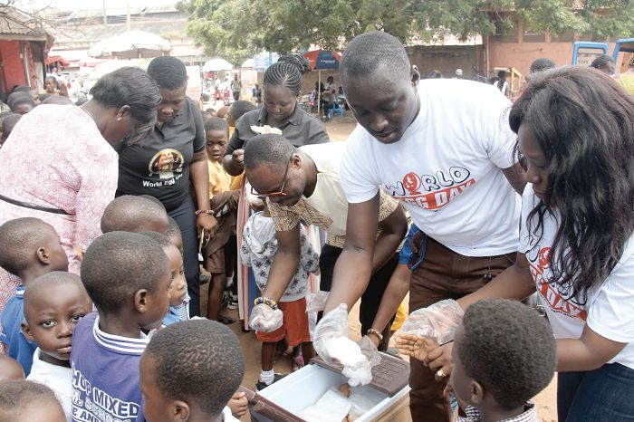  Mr Emmanuel Clottey (3rd right) being assisted by Mr David Edjah (2nd right) to share eggs to pupils of the Independence Avenue Cluster of Schools, Accra, as part of the World Egg Day celebrations. Picture: BENEDICT OBUOBI