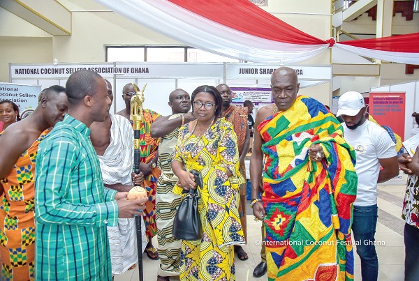 Mr Jeffery  Osei-Bonsu (left), the Managing Director of Ignite Farms, with a coconut in hand, interacting with Osahene Katekyi Busumakura (right) the Takoradimanhen, and his wife, Lady Margaret