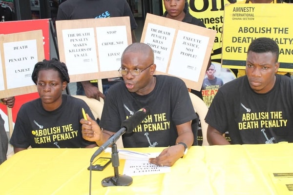 Mr Samuel Komla Agbotsey (middle), Campaigns and Fundraising Co-ordinator for Amnesty International, Ghana, addressing the public on the impact of the death penalty on children. With him are Paul Gozo (right) and Gloria Emeka, both members of AI Ghana . Picture: Patrick Dickson