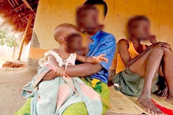  a victim of child marriage carrying a baby. Sitting with her is her husband