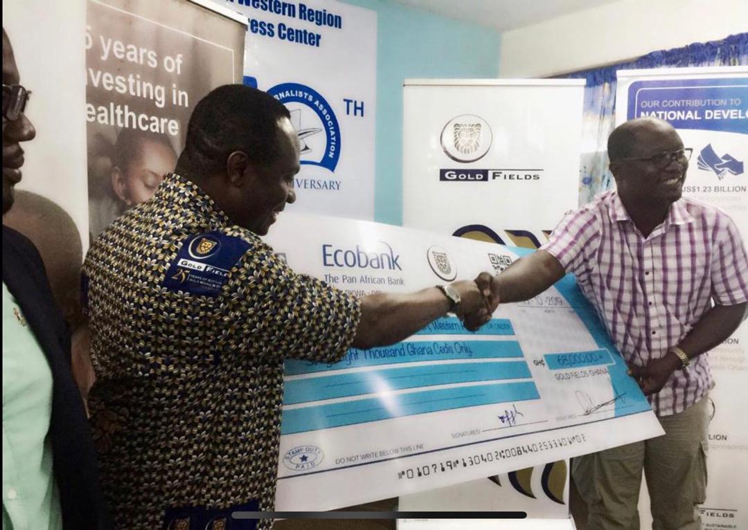 Mr Dotsey Koblah Aklorbortu, the Western Regional GJA Chairman receiving a dummy cheque from Mr Francis Eduku, the Vice President of Gold Fields Ghana in charge of Human Resource.