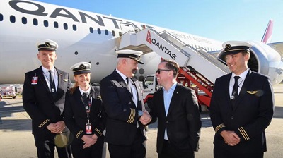 This handout photo, from Qantas, shows Qantas Group CEO Alan Joyce (C-R) shaking hands with Qantas pilot Captain Sean Golding (C-L) with the crew in front of a Qantas Boeing 787 Dreamliner plane after arriving at the Sydney international airport after completing a non-stop test flight from New York to Sydney, on October 20, 2019. (Via AFP)