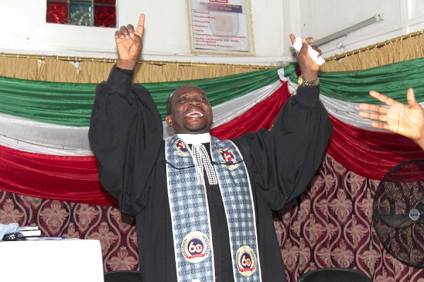 Rev Ansa praising God during the service