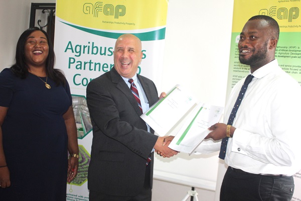  Mr Anthony Selorm Morrison (right), Chief Executive Officer of the Chamber of Agribusiness Ghana and Mr Jason Scarpone (middle), President of African Fertilizer and Agribusiness Partnership (afap), exchanging the signed Agribusiness document in Accra. With them is Nana Aisha Mohammed (left), Ghana Country Programs Manager of the afap. Picture: GABRIEL AHIABOR