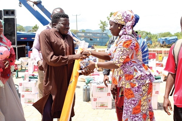 Mr Abubakari Sulley (left) receiving some items from Madam Mary Konneh, the DCE for Banda 