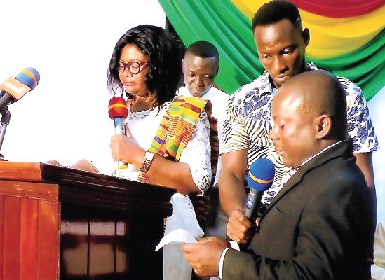 Ms Victoria Adu (left) being sworn into office by the Oda District Magistrate, Mr Kwesi Apiatse Abaidoo (right).