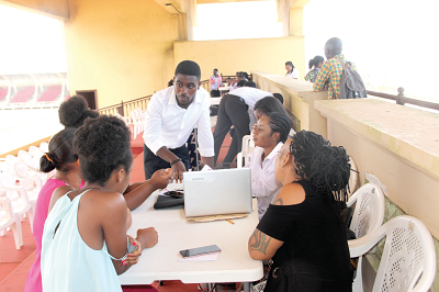 Officials of the Ghana Education Service (GES) interacting with some parents and their children checking on the Computerised School Selections Placement System at the Black Star Square in Accra.