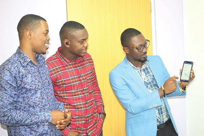  Mr Carlos Akyeampong (right) explaining the uses of the app to some workers. Picture: Gabriel Ahiabor