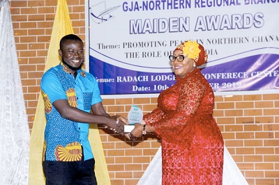 Mr Mohammed Fugu (left), a reporter with the Northern Regional office of the Graphic Communications Group Limited (GCGL), receiving an award 