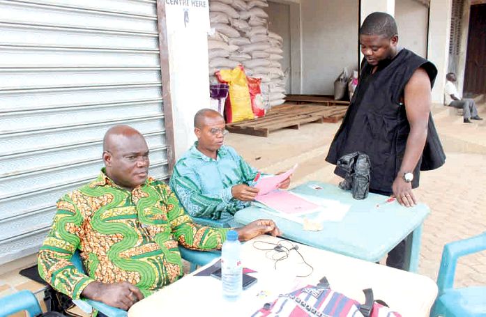 Registration officials attending to one of the voters at the Rural Development Store polling centre in Sunyani. Picture: EMMANUEL ADU-GyameraH
