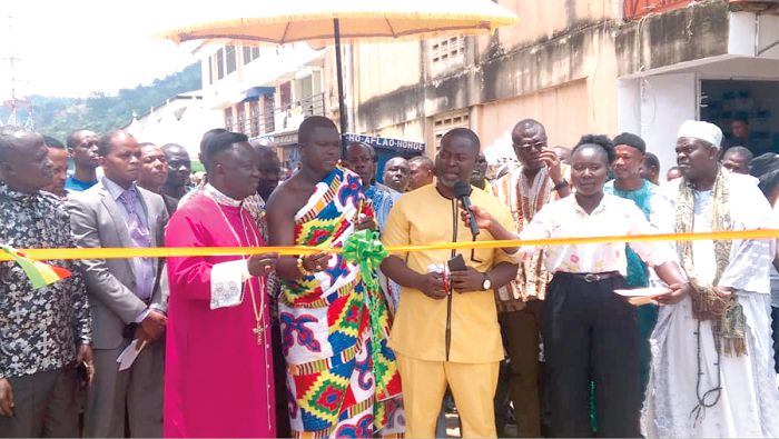  Mr Isaac Appaw-Gyasi (middle) cutting the ribbon to officially inaugurate the new lorry station and the 80 lockable market stores. Those with him are Nana Twumasi Adarkwa (4th left), and representatives of transport unions and other dignitaries