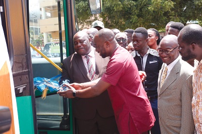  Mr Charles Annan (2nd left), Depot Manager, Aayalolo Bus Services being assisted by Prof. Samuel Nii Odai (left) to commission the shuttle services for students. Picture: NII MARTEY M. BOTCHWAY