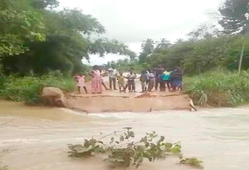Some residents standing at the edge of the broken bridge