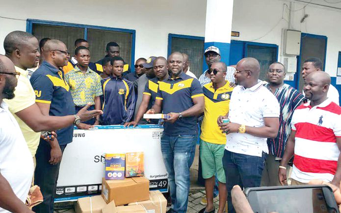  Mr Frank Owusu Boateng (4th right), a member of the group, handing over the items to Mr Adjepong (in glasses)