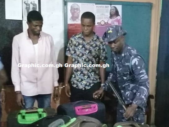 The suspects with a Customs officer after they had been arrested