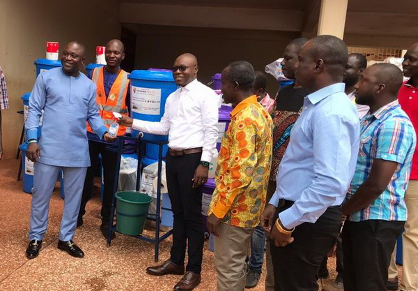 Mr Mr John Kofi Donyina (left) receiving the items from Mr Mr Kwadwo Obeng Aboagye, GM of Ghana Nuts Company Ltd. Looking on are other staff of the assembly and Ghana Nuts.