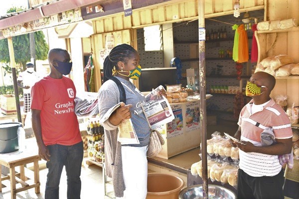 Ms Theodora Nyarko, of the Sales and Circulation Department of the Daily Graphic  having an engagement with a shop owner.  Pictures: EBOW HANSON
