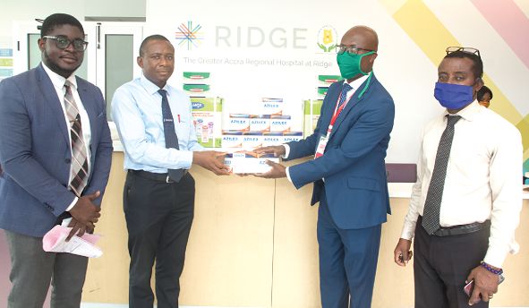  Mr Solomon Odamtten  (2nd left) presenting an item to Dr Emmanuel Srofenyo. Those with them are Mr Kwadwo Fofie (left) and Mr Basilinus Akussah (right), both members of the Unichem management team 