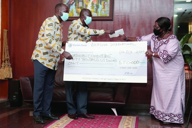 Mrs Akosua Frema Osei Opare (right), Chief of Staff receiving a cheque for $50,000 from Mr Kwesi Ofori (left), Managing Director, Rocksure, and a member of the delegation