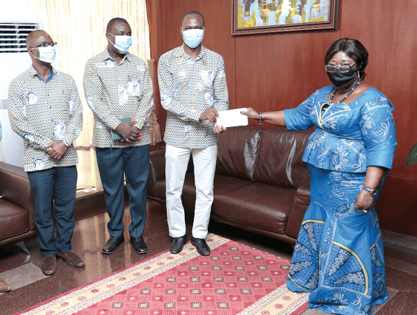  Mrs Akosua Frema Osei Opare receiving a cheque from Dr John Amaglo (2nd right), President, Ghana Institute of Surveyors, towards the Covid-19 Trust Fund, at the Jubilee House.  Picture: SAMUEL TEI ADANO