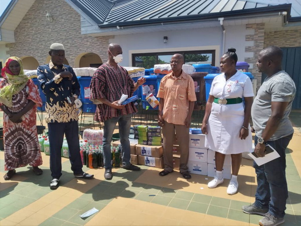 Picture shows Alhaji Sulemana (middle and in smock with nose mask) hands over the items to Mr Bakuri (right) , the Bole District Director of Health Service . In the picture with them are some staff of the directorate and party executives