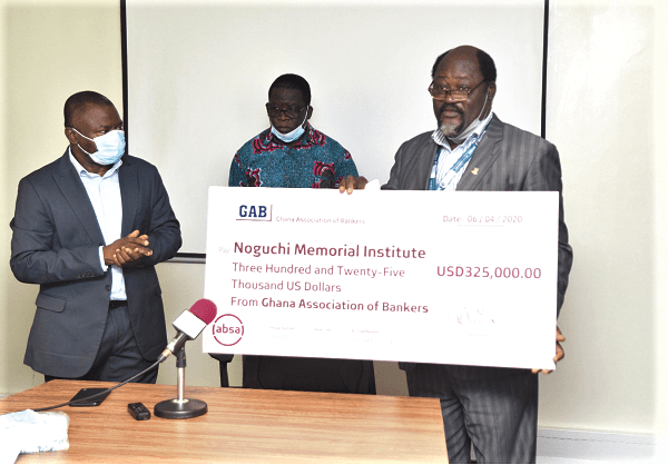 Professor Abraham Kwabena Anang (right), Director of the Noguchi Memorial Institute, showing appreciation to the Ghana Bankers Association after receiving a cheque for US$325,000 from Mr Alhassan Andani (left), President of the association