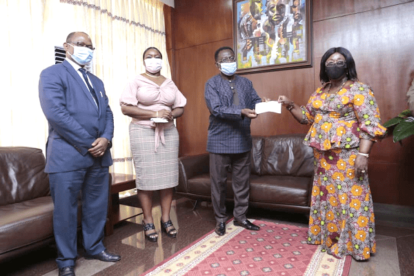 Prof. Christopher Ameyaw-Akumfi (left) presenting the cheque for the amount to Mrs Akosua Frema Osei Opare, the Chief of Staff. With them are other officials of GIIF